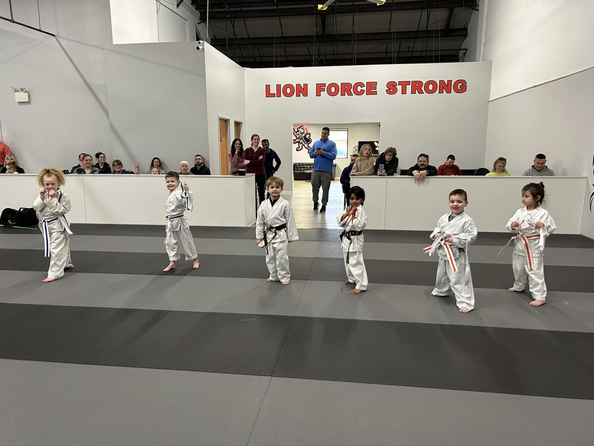 433673178_916297607168564_3383266038754148081_n a group of children wearing white karate uniforms, standing in a line on a mat in a martial arts studio